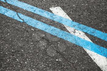 Blue double dividing line over one white on highway asphalt, closeup photo