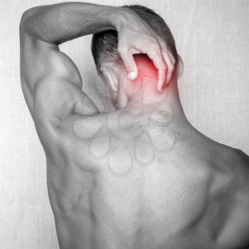 Sporty young adult man with pain in the neck. Square black and white stylized photo with red local pain spot