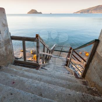 Wooden stairs going down to the sea coast. Square coastal morning seascape of Zakynthos island, Greece