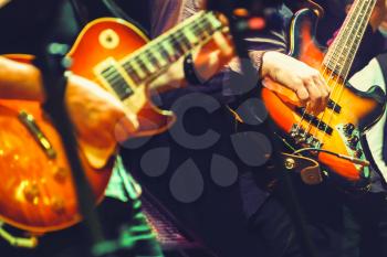 Colorful rock and roll music background, guitar players on a stage, selective focus and retro tonal correction filter effect, old instagram style