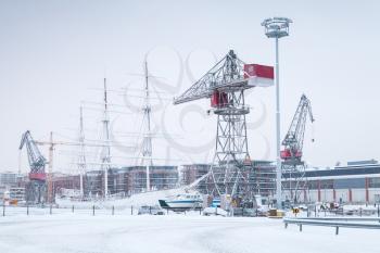 Industrial cranes and cargo ships in wnter port. Turku, Finland