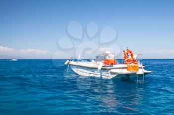 White pleasure motor boat floating on sea water near Zakynthos island, Greece