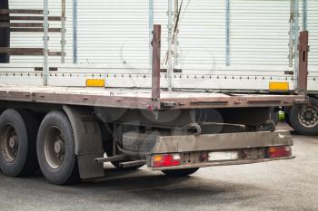 Rear fragment empty truck cargo trailer on asphalt road