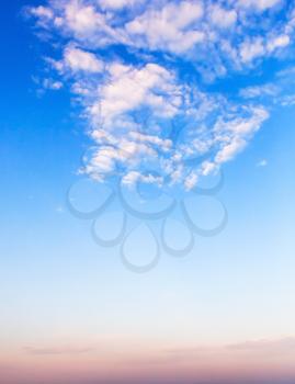 Vertical cloudscape, background photo with white clouds in bright blue morning sky
