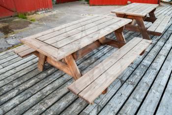 Empty wooden tables with benches stand on the pier in Norway