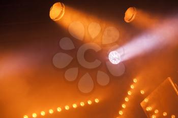 Spot lights with yellow rays in smoke, stage illumination equipment