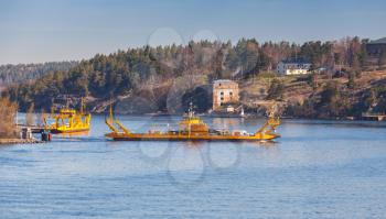 Yellow Ro-Ro ferry goes near medieval Oscar Fredriksborgs fortification. Landmarks of Vaxholm, Stockholm archipelago, Sweden