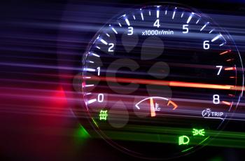 Closeup photo of modern automotive tachometer with hi speed on black background, motion blur filter effect