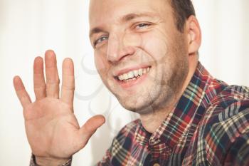 Close-up studio portrait of friendly young adult Caucasian man in colorful casual shirt