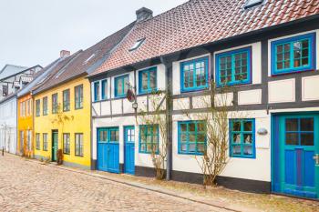 Traditional colorful living houses stand along the street in old town of Flensburg city, Germany