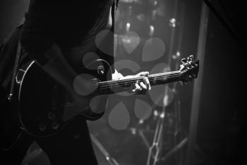 Electric guitar player on a stage, soft selective focus, black and white