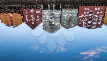 Reflections pattern in flowing water. Traditional wooden houses in old town of Trondheim, Norway. Coast of Nidelva river