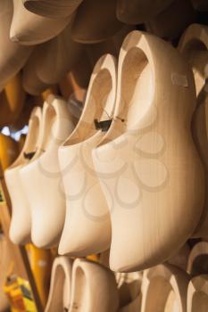 Uncolored clogs made of poplar wood. Klompen, traditional Dutch shoes for everyday use hang in souvenir shop