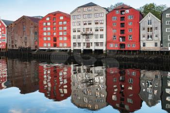 Colorful traditional wooden houses in old town of Trondheim, Norway. Coast of Nidelva river. Cold tonal correction photo filer, old style effect