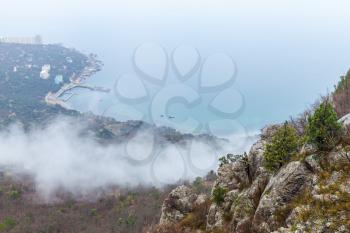 Crimea peninsula, Black Sea. Rocks and clouds. Coastal landscape of Laspi district in foggy spring day