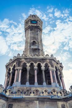 Historical clock tower under blue sky, it was built in 1901 and accepted as the official symbol of Izmir City, Turkey. Retro stylized photo with blue tonal correction filter