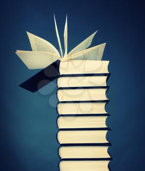 Stack of books with open book on top
