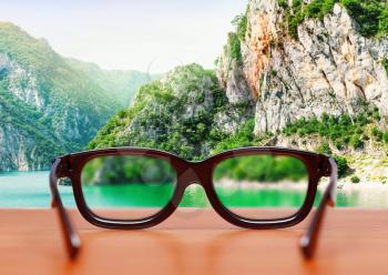 Eyeglasses on the table against the mountain landscape