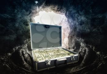 Case full of dollars stands inh the cave