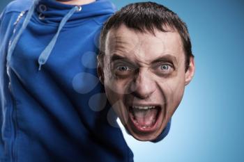 Man with screaming head instead of a palm over blue