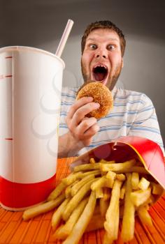 Portrait of expressive man eating fast food