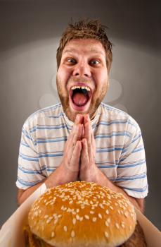 Portrait of happy man praying for fast food