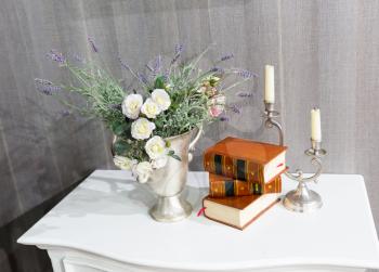Flowers, books and a candlestick on the table