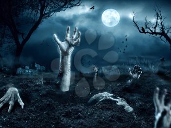 Zombie hand coming out of his grave. Full moon, halloween night