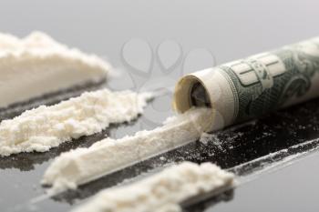 Cocaine lines and 10 dollars note on grey background
