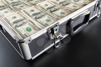 Closeup picture of case full of dollar on gray background