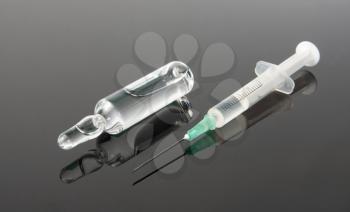 Medicine and  syringe on gray surface