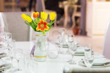 Served table with tulips in vase