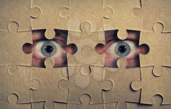 Eyes look out from the holes in jigsaw puzzle