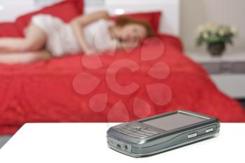 Mobile phone with sign and blurred sleeping woman