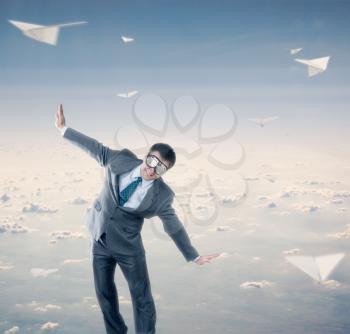 Businessman flying wearing goggles isolated on sky background