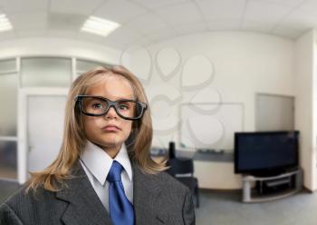 Little serious girl in the office in funny spectacles