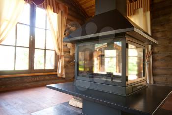 Interior of wooden chalet with big modern fireplace