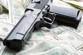 Heap of $100 dollar bills and handgun