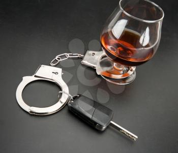 Car key locked to glass of alcohol by handcuffs