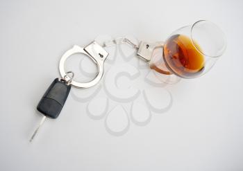 Car key locked to glass of alcohol by handcuffs