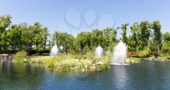 Beautiful pond in spring park with fountains
