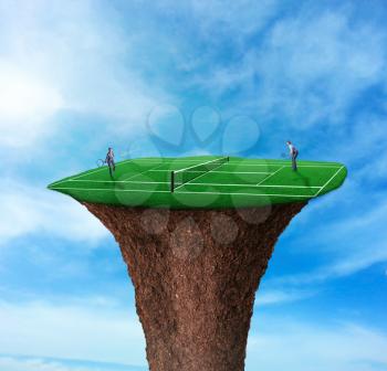 Businessman and businesswoman playing tennis the top of the cliff