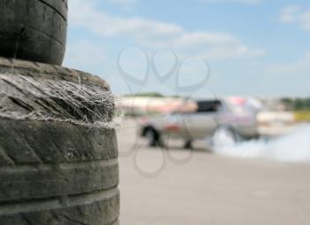 Used racing tires with sport car on background