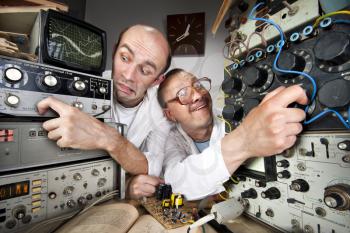Two funny nerd scientists working at vintage technological laboratory