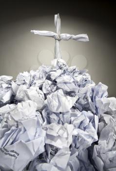 Deadly paperwork. Grave with cross made of crumpled papers