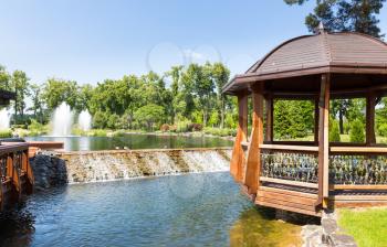 Beautiful lake in spring park with wooden summer-house