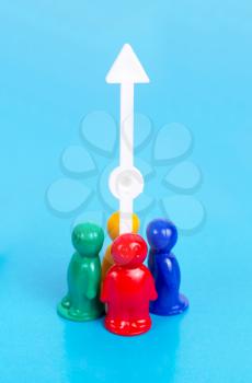 Growth concept. Group of the toy people and arrow pointing up