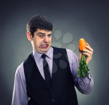 Small carrot in hands of a businessman