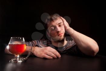 Man locked to glass of alcohol by handcuffs