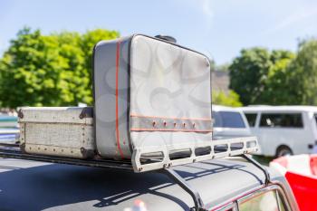 Old grey suitcases standing on the car top